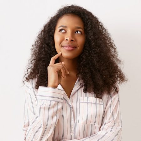 amazing-adorable-girl-african-american-origin-having-dreamy-pensive-facial-expression-looking-up-smiling-holding-fore-finger-her-chin-thinking-vacation-plans-exciting-future_343059-2623